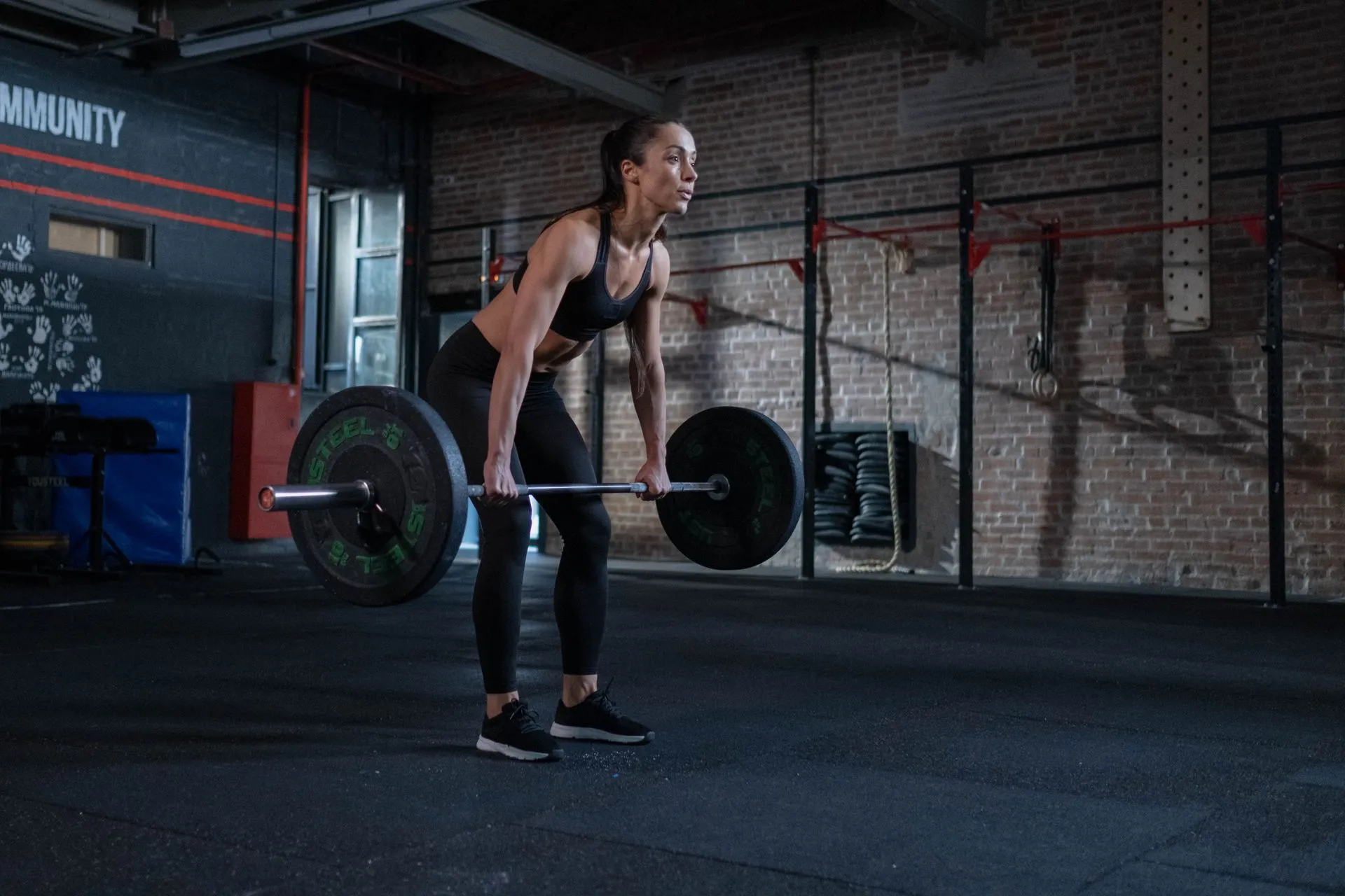 An athlete practising a barbell deadlift in the gym